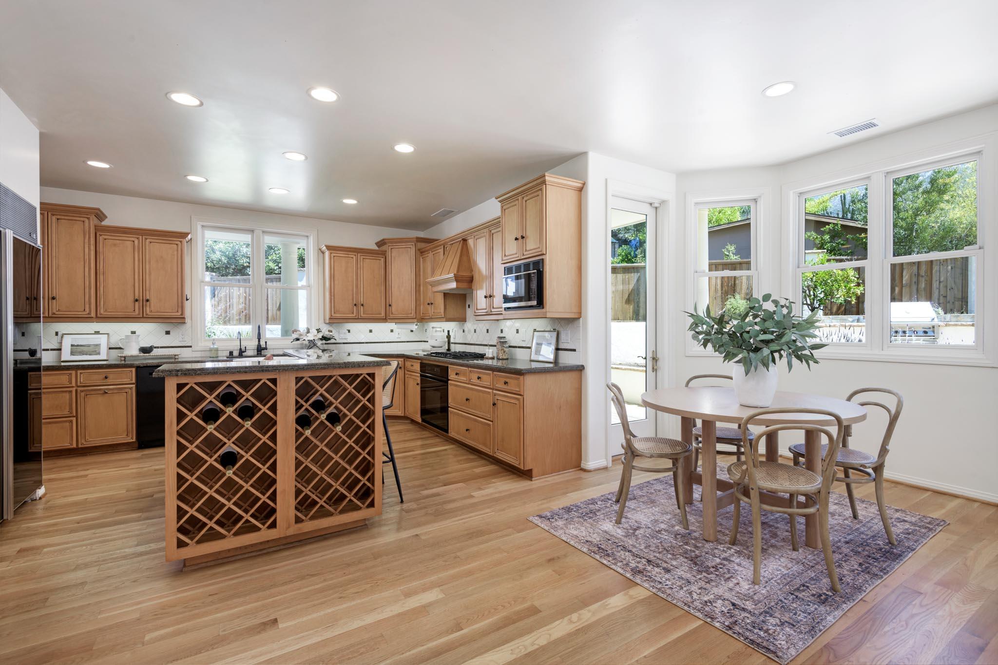 1444 Tunnel Road Santa Barbara, CA 93105 - Photo 11 of 24 a kitchen with stainless steel appliances granite countertop a stove a sink a microwave a dining table and chairs