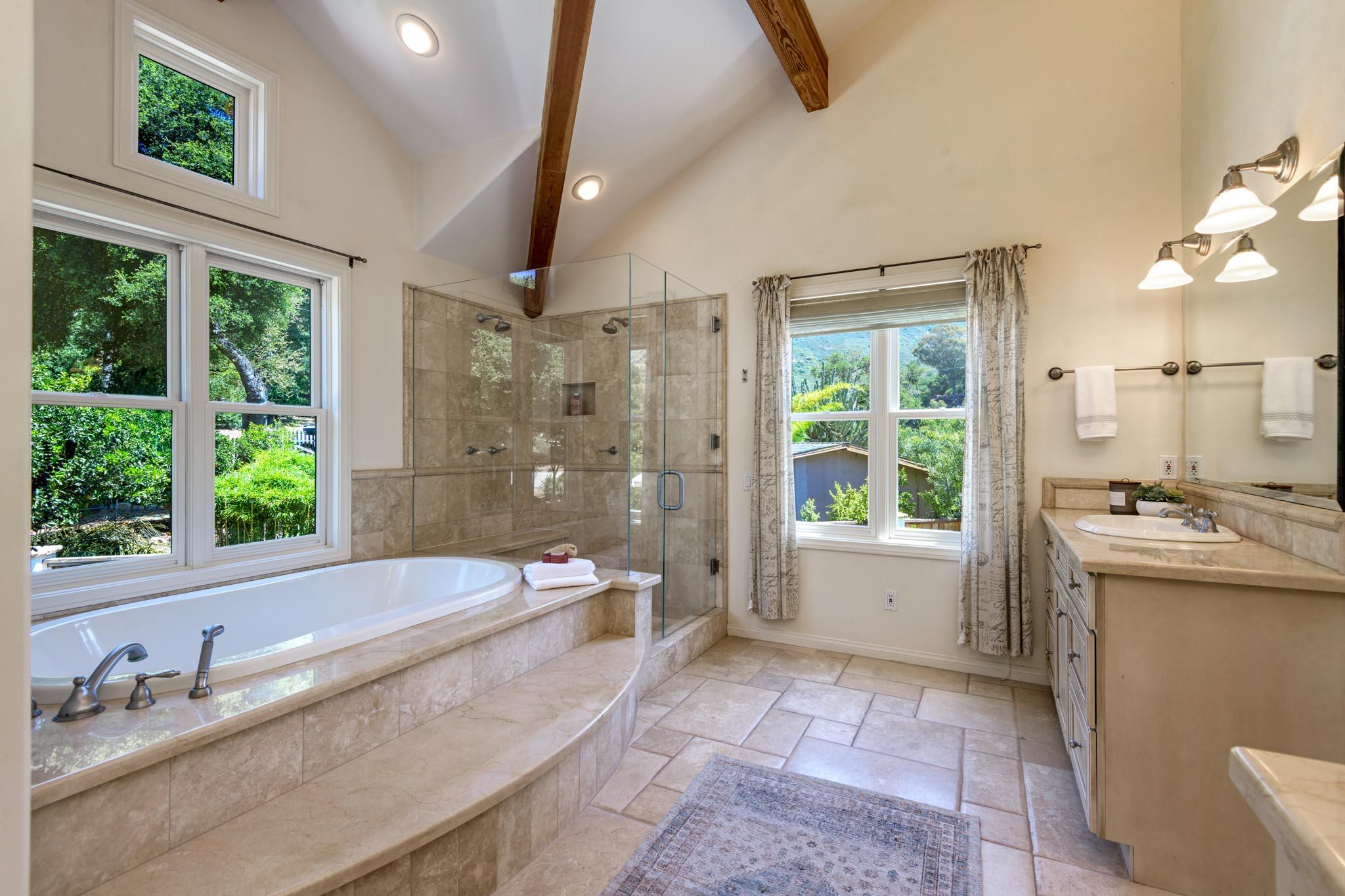 1444 Tunnel Road Santa Barbara, CA 93105 - Photo 14 of 24 a bathroom with a granite countertop tub sink and mirror
