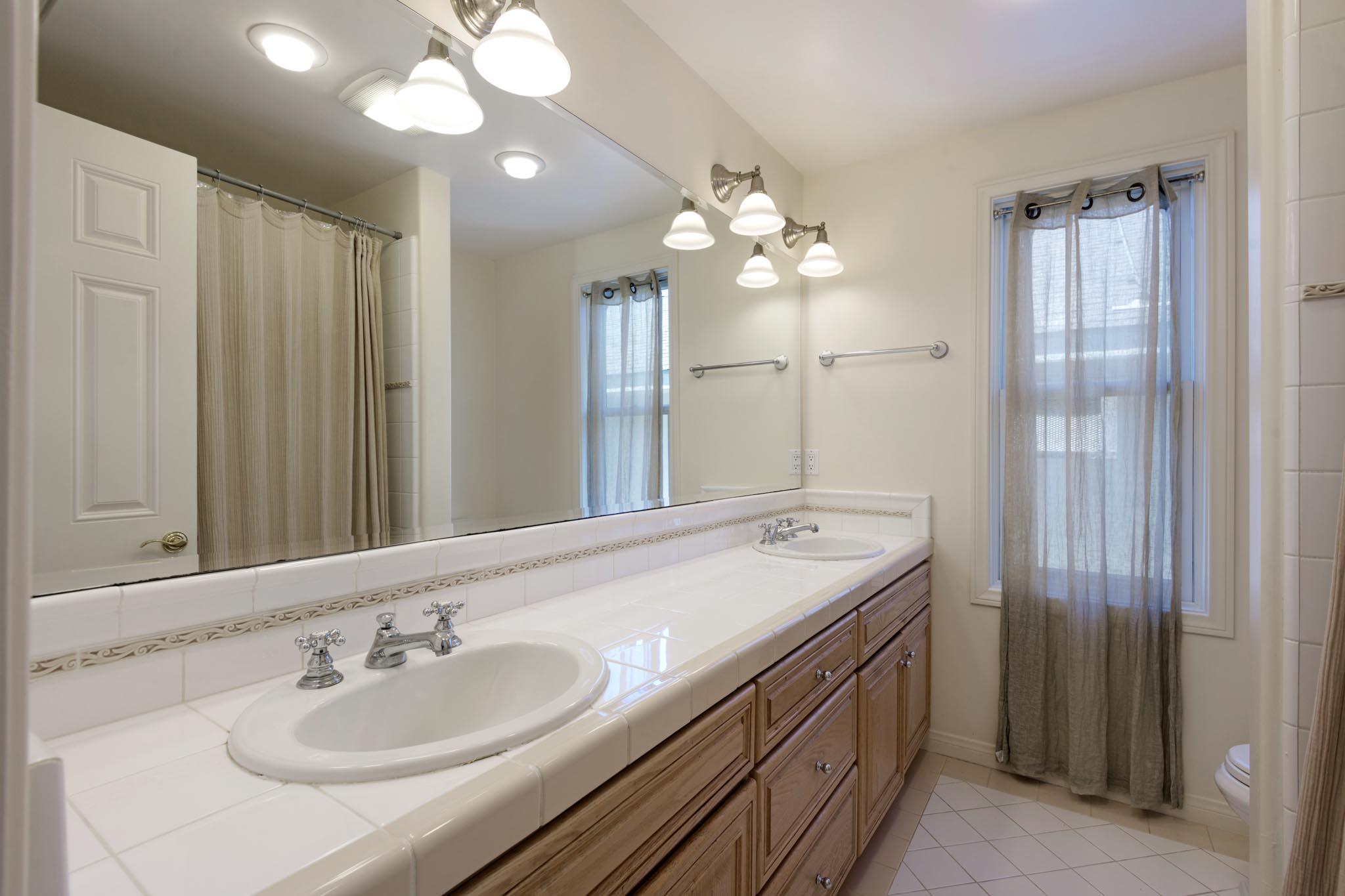 1444 Tunnel Road Santa Barbara, CA 93105 - Photo 21 of 24 a bathroom with a double vanity sink and a mirror