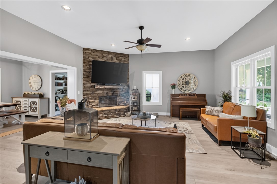 1504 Double Springs Road Townville, SC 29689 - Photo 7 of 49 A floor-to-ceiling stone fireplace anchors this bright living space with clean wood-look flooring.
