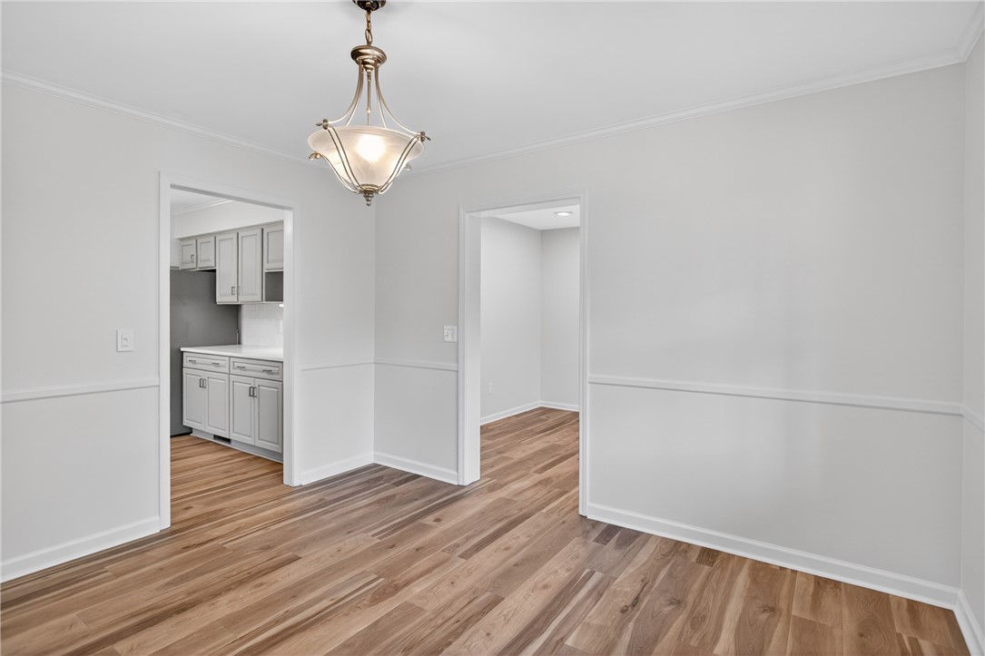 9 Lookout Lane Salem, SC 29676 - Photo 12 of 46 A well-lit interior space features beautiful wood flooring, crown molding, and a chandelier.