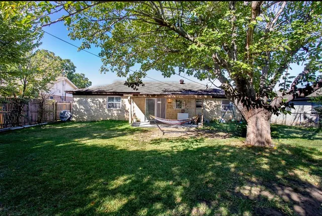 a view of a house with backyard and a tree
