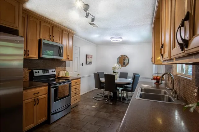 a kitchen with stainless steel appliances granite countertop a stove sink microwave and cabinets