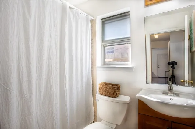 a bathroom with a toilet a sink and a mirror