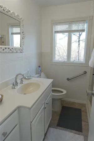 a bathroom with a sink toilet and window