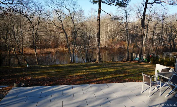 a backyard of a house with trees and outdoor seating