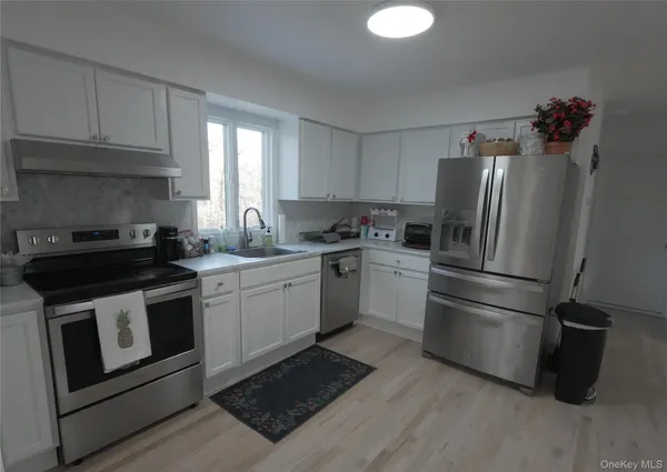a kitchen with a refrigerator sink and cabinets