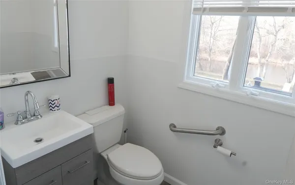 a bathroom with a sink mirror and toilet