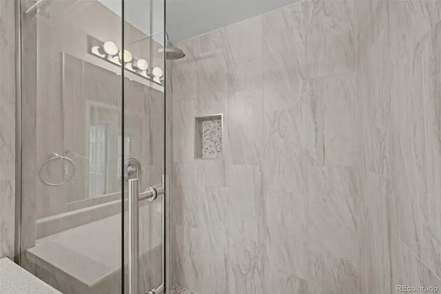 a bathroom with a sink a toilet a mirror and shower