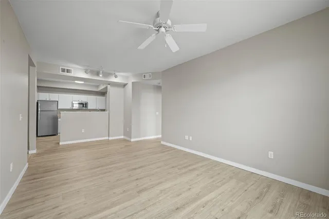 wooden floor in an empty room with a kitchen