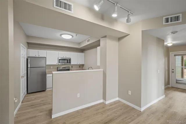 a kitchen with refrigerator cabinets and wooden floor