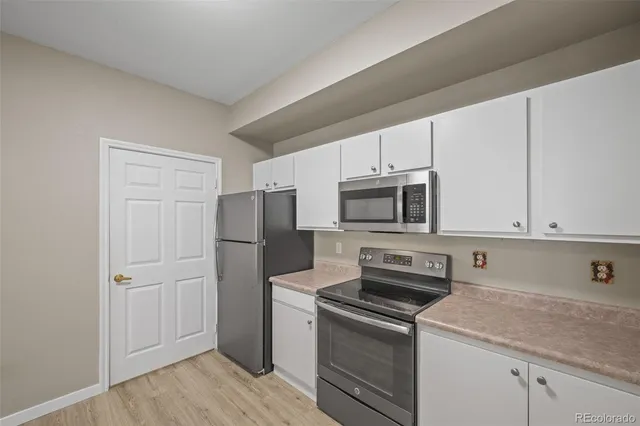 a kitchen with a refrigerator stove and cabinets