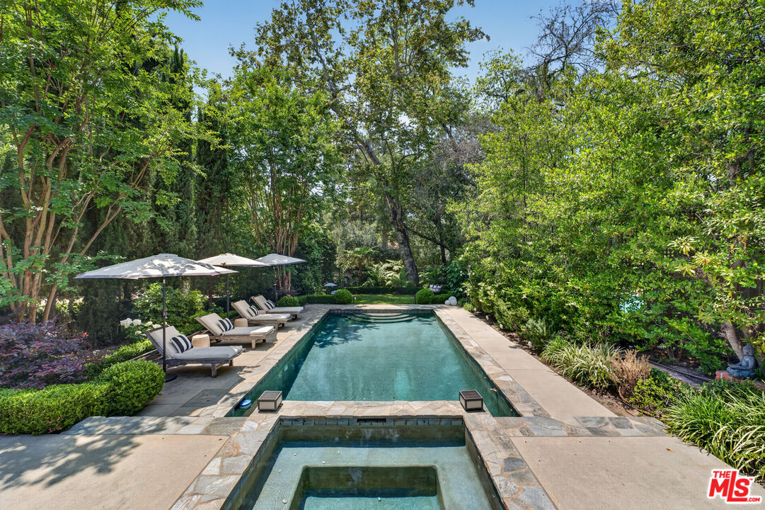760 South San Rafael Avenue Pasadena, CA 91105 - Photo 9 of 45 a view of a swimming pool with lawn chairs under an umbrella