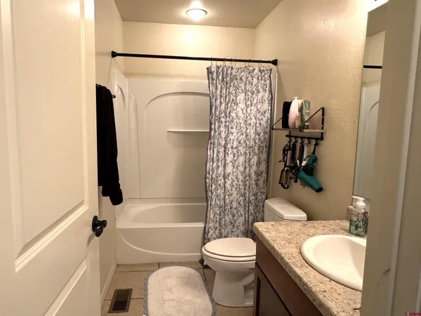 a bathroom with a granite countertop toilet and a sink