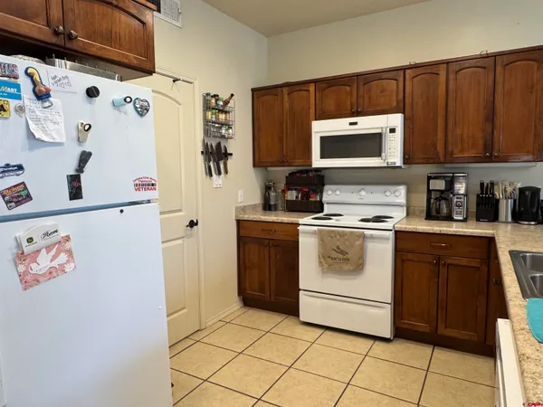 a white kitchen with a stove top oven a sink and cabinets