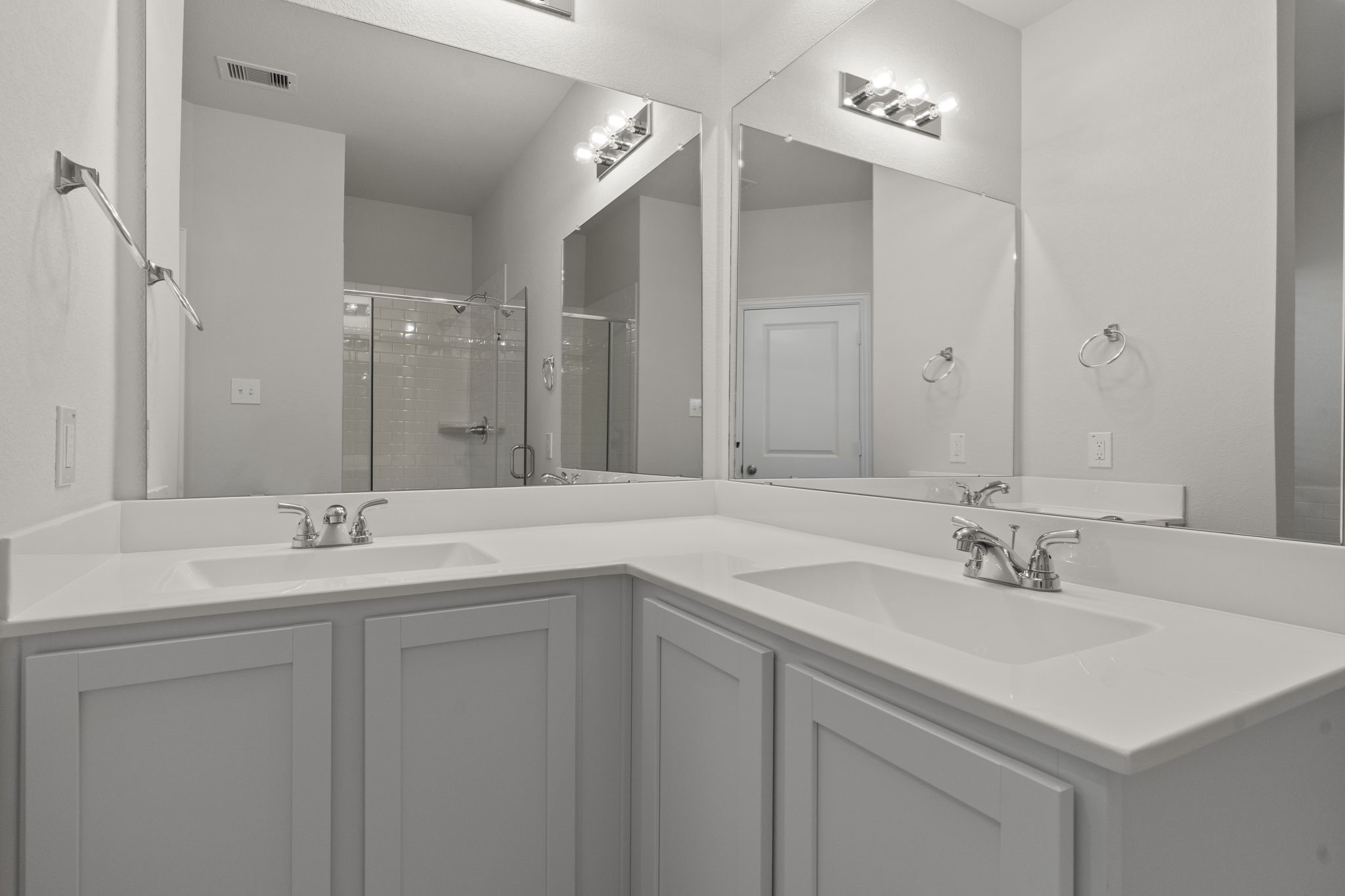 22218 Rome Breeze Drive Hockley, TX 77447 - Photo 20 of 34 Dual vanities and expansive mirrors in the primary bath provide plenty of space for morning routines. The elegant cabinetry and clean design add a touch of sophistication to this private ensuite.