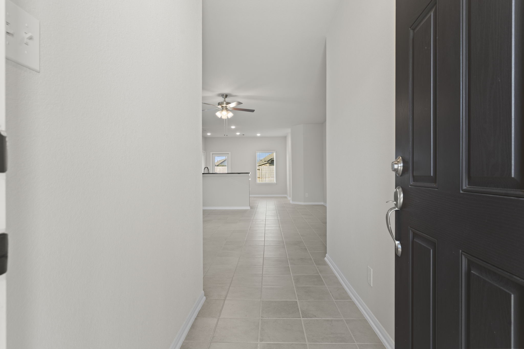 22218 Rome Breeze Drive Hockley, TX 77447 - Photo 5 of 34 Step inside to a bright, open foyer that instantly feels fresh and welcoming. The neutral large tile flooring flows seamlessly throughout, guiding you toward the home’s open concept living spaces filled with natural light.