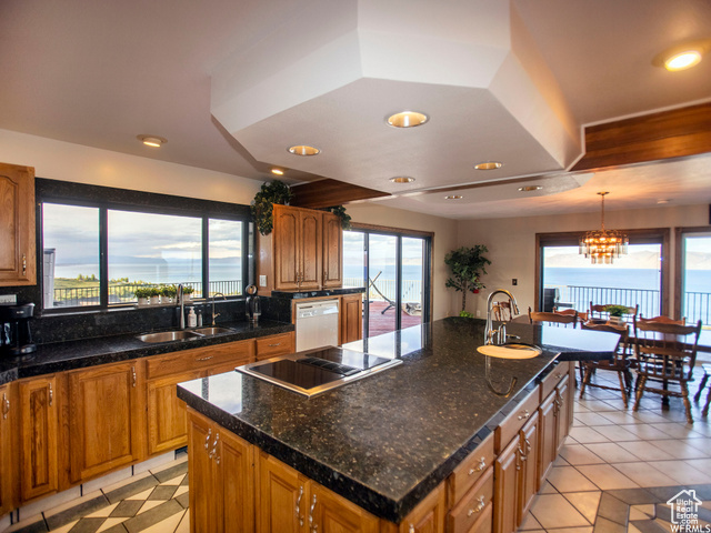 588 Raspberry Patch Road Garden City, UT 84028 - Photo 18 of 74 Kitchen with a center island, brown cabinets, white dishwasher, hanging light fixtures, and light tile patterned floors