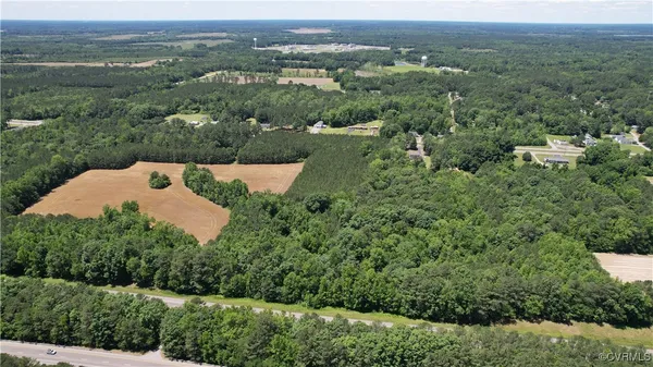 an aerial view of a house with a lush green forest