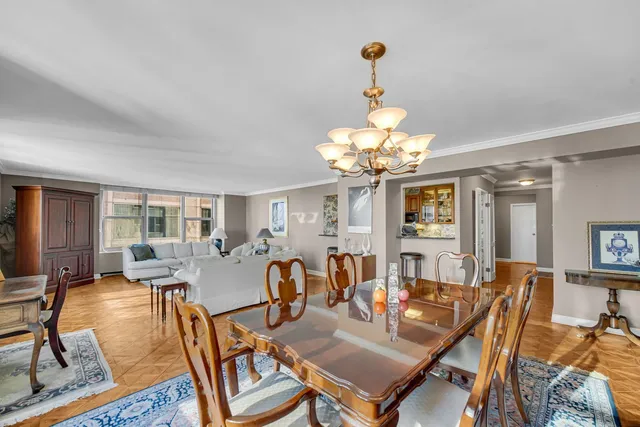 a view of a dining room with furniture a chandelier and wooden floor