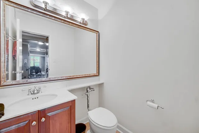 a bathroom with a toilet a sink and mirror