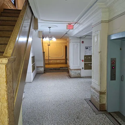 a view of a hallway with wooden floor and a living room