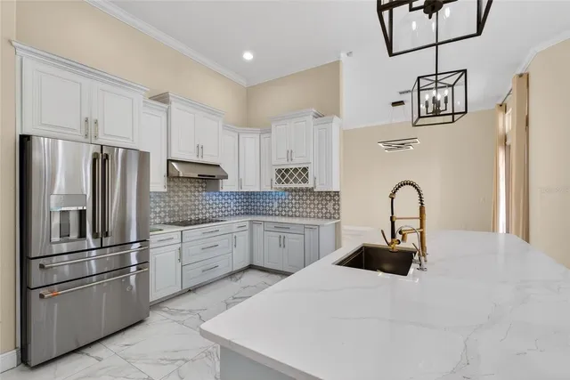 a kitchen with stainless steel appliances granite countertop a refrigerator and a stove top oven