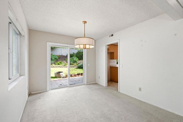 a view of an empty room with window and cabinet