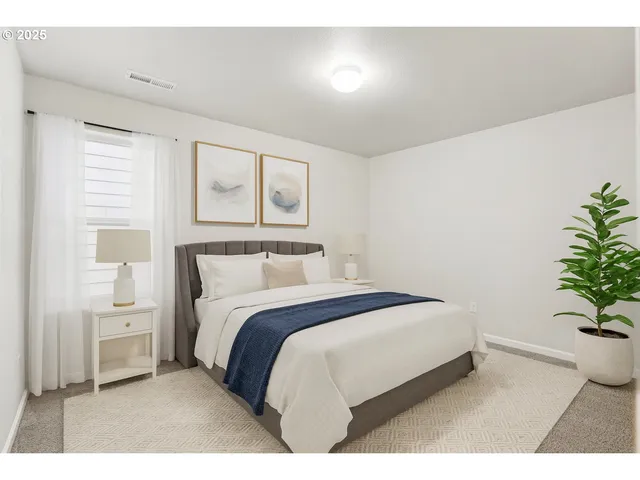 a bedroom with a bed and a potted plant