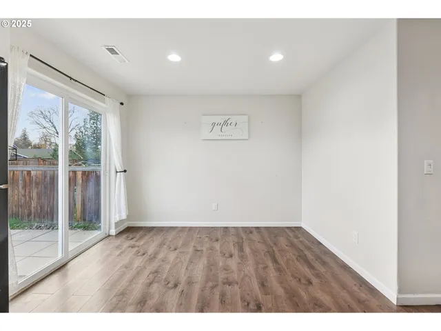 a view of room with wooden floor and windows