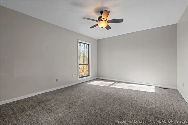 an empty room with a window and a fan