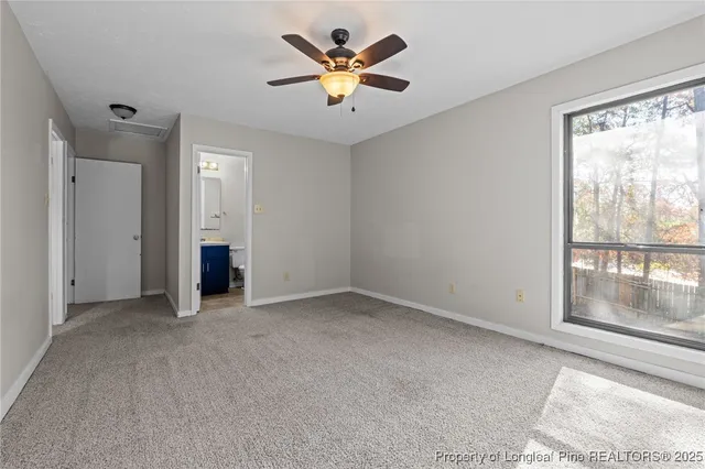 an empty room with closet and a ceiling fan