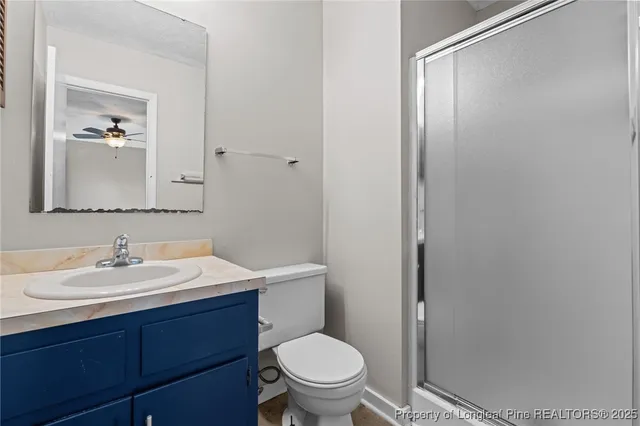 a bathroom with a toilet a sink a mirror and vanity