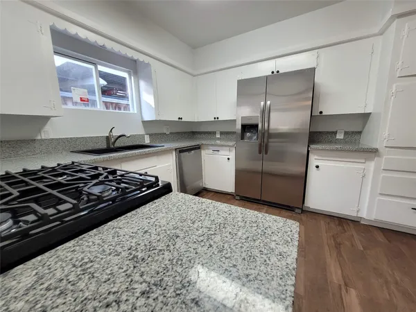 a kitchen with a stove a refrigerator and a sink