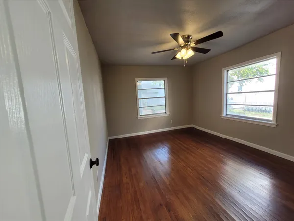 a view of a livingroom with wooden floor and a ceiling fan