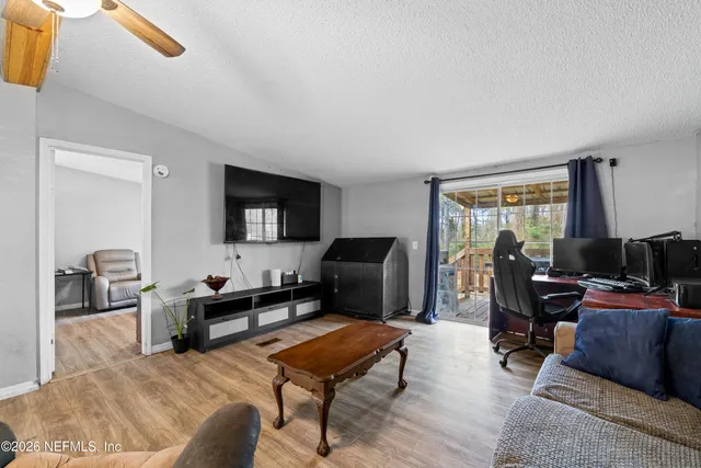 a living room with furniture a flat screen tv and a window