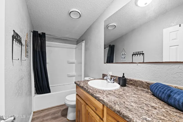 a bathroom with a granite countertop sink toilet and shower