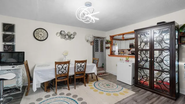 a bedroom with a bed a flat tv screen and a dresser