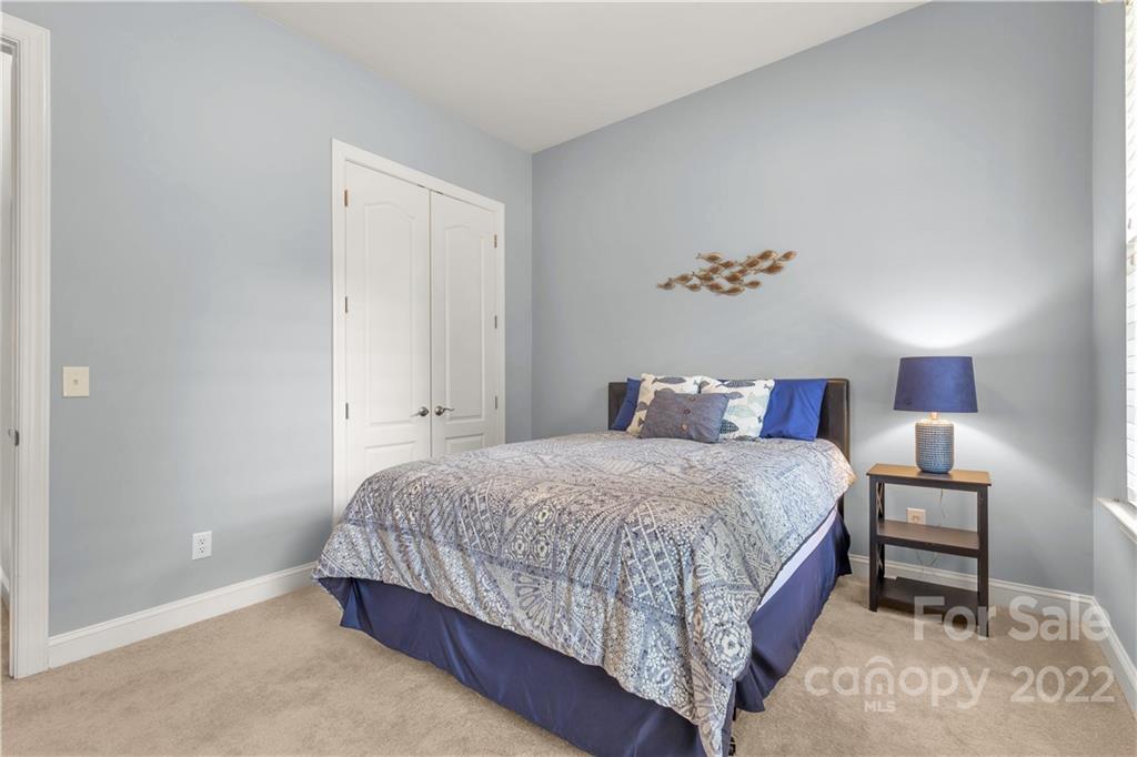 932 Treasure Court Fort Mill, SC 29708 - Photo 19 of 34 a bedroom with a bed and a night stand