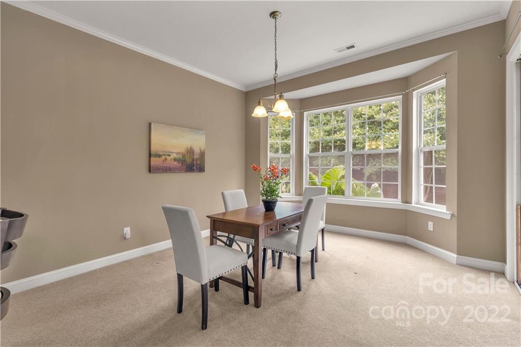 932 Treasure Court Fort Mill, SC 29708 - Photo 10 of 34 a dining room with furniture a chandelier and wooden floor