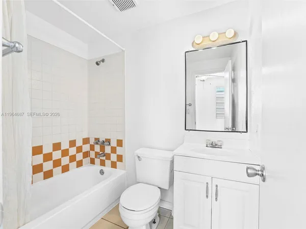 a bathroom with a toilet sink vanity tub and shower