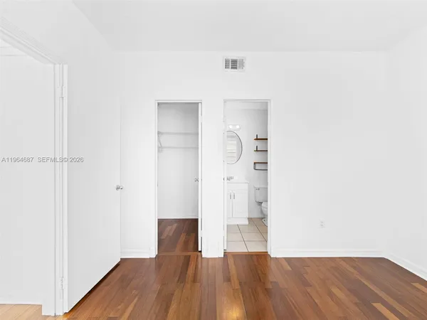 a view of empty room with wooden floor