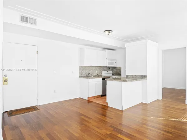 a kitchen with a refrigerator and white cabinets