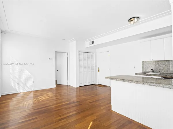 a kitchen with granite countertop a stove and a wooden floors