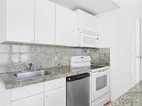 a kitchen with stainless steel appliances granite countertop a sink stove and cabinets