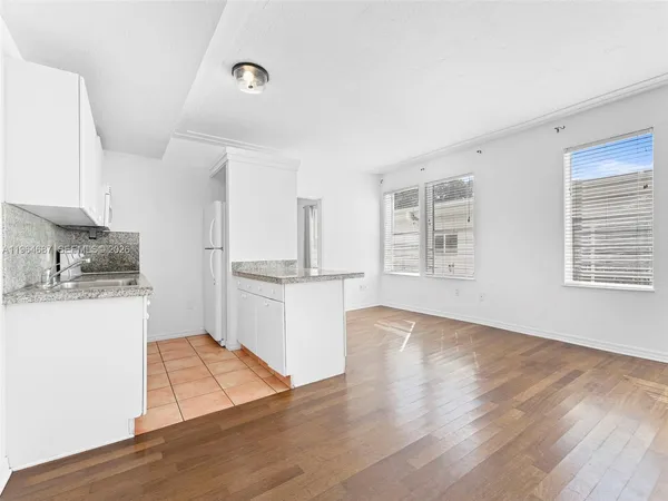 a view of a kitchen with wooden floor and a window