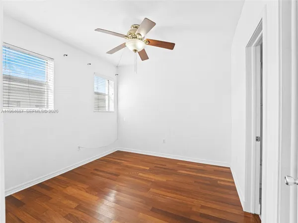 a view of empty room with wooden floor