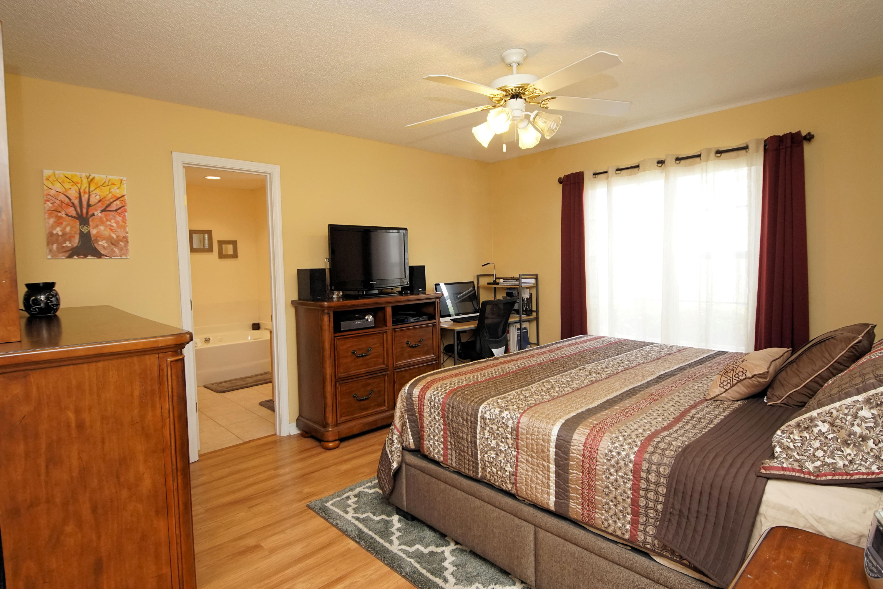 1956 Woodcrest Ridge Fort Walton Beach, FL 32547 - Photo 12 of 23 a bedroom with a large bed and a flat tv screen on dresser
