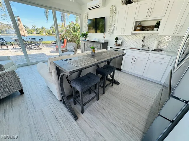 a kitchen with granite countertop a table chairs stove a sink dishwasher and cabinets with wooden floor