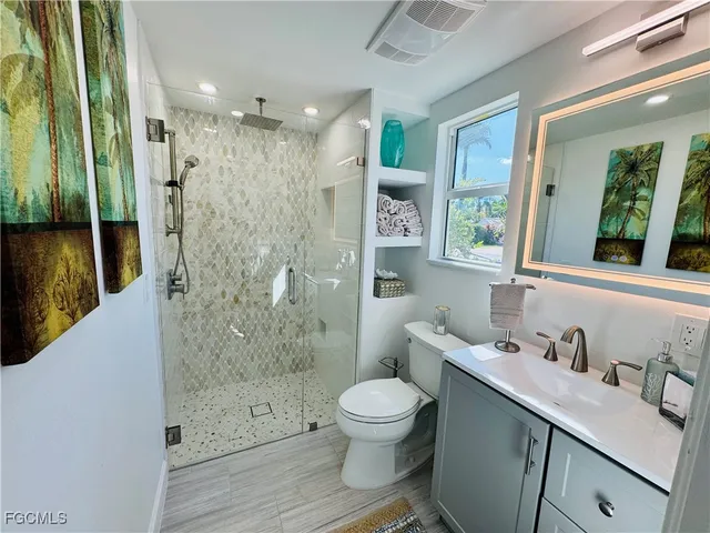 a bathroom with a sink a toilet and shower